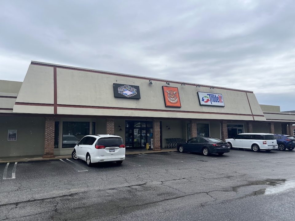 The storefront at 2916 Sunset Avenue, with the Game Nook, Geek Valhalla and Trade it! signs above the entrance and free parking directly in front of the door.